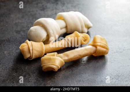 Delikatesse für Hunde. Kauknochen für Hund auf schwarzem Tisch. Stockfoto