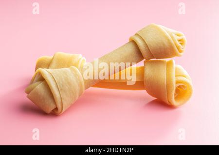 Delikatesse für Hunde. Kauknochen für Hund auf rosa Hintergrund. Stockfoto