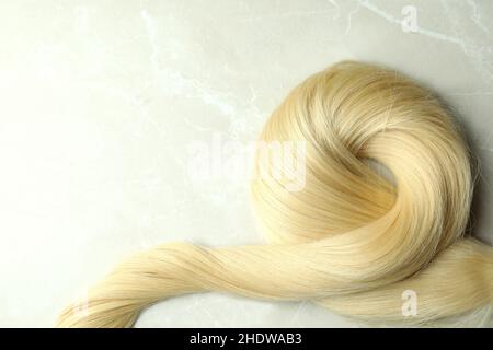 Eine Sperre von blonden weiblichen Haaren auf hellem Hintergrund Stockfoto