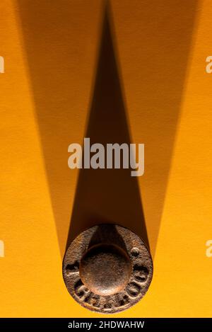 Bleigewicht von einem Kilogramm senkrecht von oben auf einer gelben Oberfläche mit doppeltem Schatten fotografiert Stockfoto
