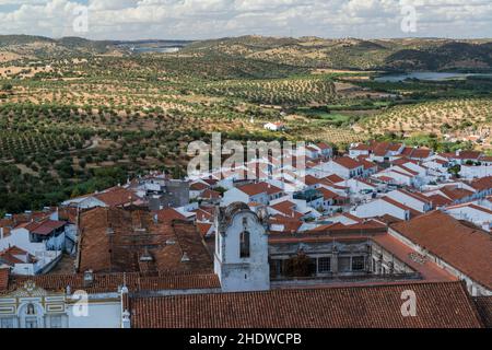 Blick von der Spitze des Turms der Burg von Moura auf dem Convento do Carmo, weiß getünchte Häuser und Landschaft mit Olivenbäumen übersät. Alentejo, Portugal Stockfoto