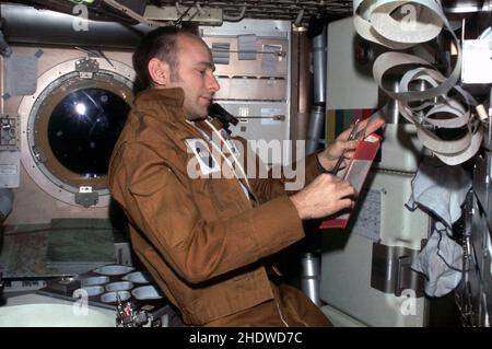 (Juli-September 1973) --- Astronaut Alan L. Bean, Kommandant von Skylab 3, liest Daten aus dem Buch in seiner rechten Hand, während er im Stationsraum des Besatzungsquartiers der Skylab-Raumstation Orbital Workshop (OWS) Teledruckband in seiner linken Hand hält. Dieses Foto wurde mit einer Nikon-Kamera aus dem Jahr 35mm aufgenommen, die von einem Bean-Mitbesetzer während der 56,5-tägigen zweiten bemannten Skylab-Mission in der Erdumlaufbahn gehalten wurde. Stockfoto