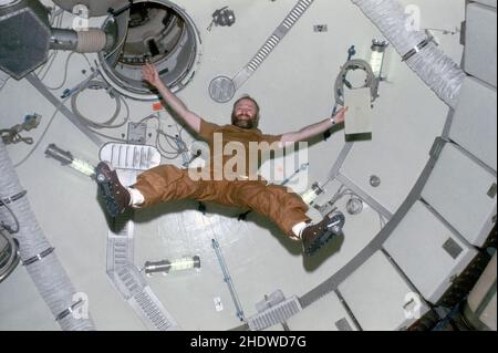 Astronaut Gerald P. Carr, Kommandant der Skylab 4-Mission, demonstriert die Auswirkungen der Schwerelosigkeit, während er im Erdorbit im vorderen Kuppelbereich der Orbital-Werkstatt der Skylab-Raumstation schwebt. Stockfoto