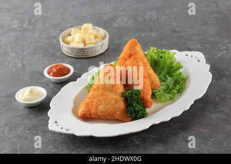 Triangle Fried Risoles oder Risol ist indonesisches traditionelles Street Food aus Mehlhaut mit Kartoffel, Käse und Gemüse im Inneren. Speicherplatz Kopieren Stockfoto