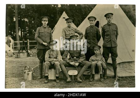 Originalpostkarte aus der Zeit WW1 von jungen Rekruten in einem Offiziersschullager - es handelte sich um Officer Training Corps (Junior Division) von der Charterhouse School des Königlichen West-Surrey-Regiments der Königinnen (die Königinnen) - die in Stoughton Barracks in Guildford stationiert war. Auf ihren Cap-Abzeichen haben die Rekruten eine Version des Queens-Emblems mit einem Charterhouse-Banner anstelle eines Queens-Banners unter dem Paschal-Lamm-Symbol. Auf dem RH Zelt steht Corps 8 Hütte, die Jungen haben ein Kartause 19 Schild zu ihren Füßen. Der ältere Rekrut, der den Stab hält, ist vielleicht ein Anführer oder Mentor der jüngeren Jungen. GROSSBRITANNIEN Stockfoto