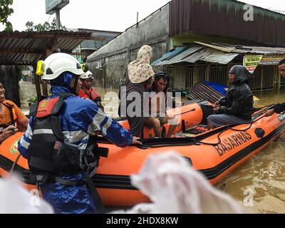 (220107) -- JAYAPURA, 7. Januar 2022 (Xinhua) -- Mitglieder der Nationalen Such- und Rettungsbehörde (Basarnas) evakuieren Menschen mit dem Boot, nachdem die Überschwemmung Jayapura, Indonesien, am 7. Januar 2022 getroffen hatte. Starke Regenfälle, die von Donnerstagabend bis Freitagmorgen Jayapura heimgesucht hatten, verursachten Überschwemmungen in einer Reihe von Gebieten. (BASARNAS/Handout via Xinhua) Quelle: Xinhua/Alamy Live News Stockfoto