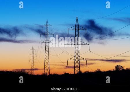 Hochspannungs-Stromübertragungstürme, Stromleitungen nach Sonnenuntergang. Schöner Dämmerungshimmel im Hintergrund. Strom, Stromversorgung, Technologie und Stockfoto