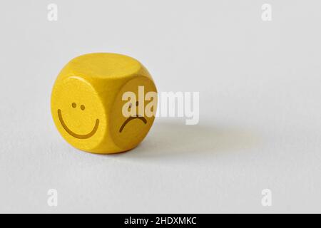 Gelbe Würfel mit positivem und negativem Ausdruck auf weißem Hintergrund Stockfoto