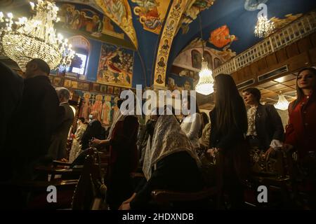 Palästinensische Gläubige aus der griechisch-orthodoxen Gemeinde beten am 7. Januar 2022 in der St. Porphyrios Kirche in Gaza City während der Weihnachtsmesse. Stockfoto