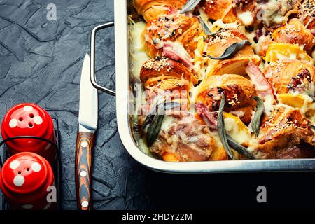 Gebackene Croissants mit Mozzarella-Käse, Speck, gekochtem Schweinefleisch und Salbei. Stockfoto