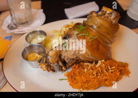 Gebratenes Schweinefleisch Eisbein Eisbein mit geschmorter gekochtem Kohl und Senf auf Holzbrett Stockfoto