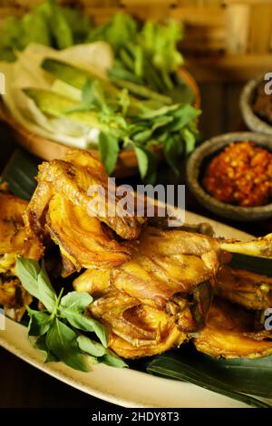 Ayam Goreng. Gebratenes indonesisches Huhn serviert mit Chiliporte, Gemüse und gedämpftem Reis Stockfoto