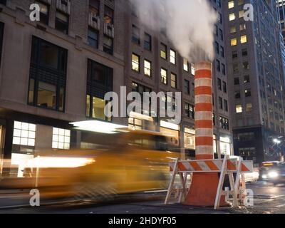 Langzeitaufnahme eines Taxis und eines Dampfstapels auf der Madison Avenue. Stockfoto