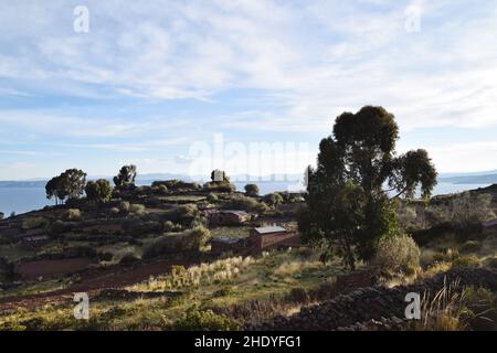 Blick auf die Landschaft auf der Insel Taquile mit dem Titicacasee in der Ferne. Foto aufgenommen bei Sonnenuntergang auf der Insel Taquile in Peru, Südamerika. Stockfoto