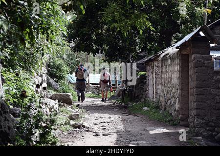 Zwei Personen, die auf Abenteuerreise sind, wandern auf dem Inka-Pfad nach Machu Picchu, Peru. Touristen mit Rucksäcken zu Beginn der Wanderung an einem sonnigen Tag. Stockfoto