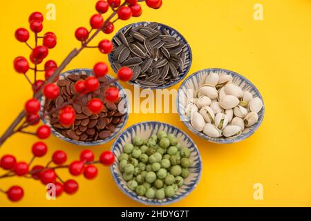 Tet Holiday, Lunar New Year, chinese New Year Concept . Getrocknete Sonnenblumen, Lotos, Wassermelonen und Kürbiskerne Draufsicht isoliert auf Gelb. Tet-Snacks Stockfoto