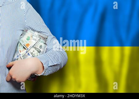 Amerikanische Dollar Bargeld in der Hand auf Flagge der Ukraine Hintergrund Stockfoto