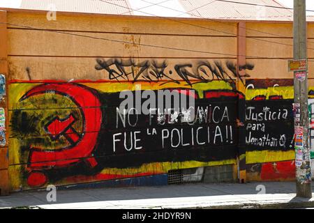 Es war (nicht) die Polizei. Gerechtigkeit für Jonathan Q' Protestslogan, gemalt über dem Wandgemälde der Kommunistischen Partei, La Paz, Bolivien. Jonathan Quispe Vila war Student an der UPEA (Universidad Pública de El Alto) Universität. Er starb am 24. Mai 2018, nachdem er an Protesten teilgenommen hatte, die eine Erhöhung des Budgets für die Universität forderten, bei der es zu gewalttätigen Zusammenstößen mit der Polizei kam. Er wurde unter unklaren Umständen von einem Marmor (canica) angeschossen, die Polizei verweigerte zunächst die Verantwortung. Der Polizeileutnant Cristian Casanova wurde im folgenden Jahr nach einer Untersuchung zu 5 Jahren Gefängnis für seinen Tod verurteilt. Stockfoto