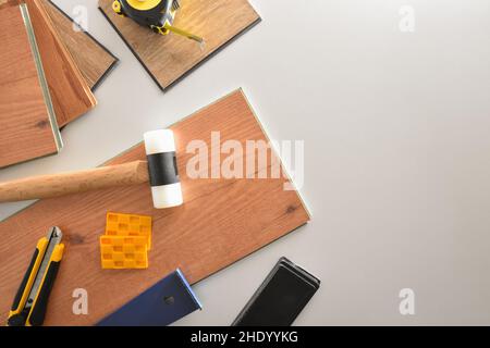 Hintergrund Parkett Errichter Material und Werkzeuge auf weißer Tischplatte Stockfoto