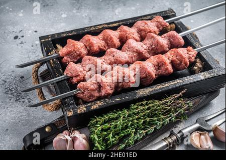 Shish Kebab aus Raw Hackfleisch Lamm und Rindfleisch, türkischen adana Kebab. Grauer Hintergrund. Draufsicht Stockfoto