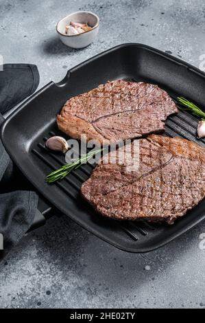 Geröstet auf Grillpfanne Rindfleisch marmorierte Fleischsteaks. Grauer Hintergrund. Draufsicht Stockfoto