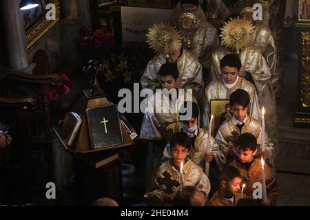 Palästinensische Gläubige der griechisch-orthodoxen Gemeinde beten während der Weihnachtsmesse in der St. Porphyrios Kirche. Die Mehrheit der orthodoxen Gläubigen feiert Weihnachten am 7. Januar. Die Kirchen in Rumänien, Bulgarien, Zypern und Griechenland markieren sie am 25. Dezember zusammen mit anderen christlichen Konfessionen. (Foto von Ahmed Zakot / SOPA Images/Sipa USA) Stockfoto