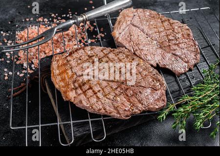 BBQ gegrilltes Rinderfleisch Sirloin Steaks auf dem Grill. Schwarzer Hintergrund. Draufsicht Stockfoto