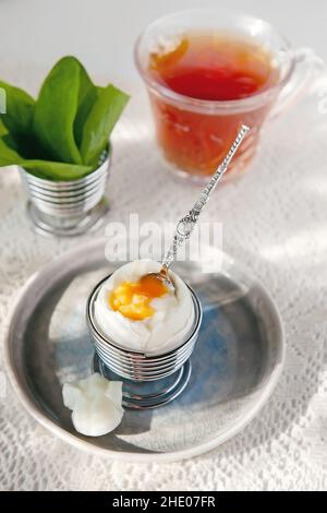 Gekochtes, weich gekochtes Ei mit heißem Tee ist ein diätetisches Frühstück. Kalorienarme Lebensmittel . Fitness-Frühstück. Stockfoto