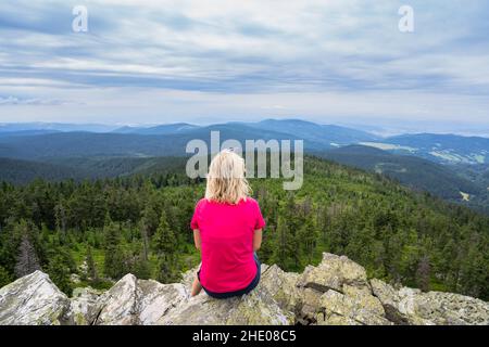 Mädchen Reisende Gefühl frei genießen Blick auf Mountains.Woman sitzt auf Felsen nach climbing.Adventure, Sport, Aktivität, Fernweh Freiheit Reisekonzept. Stockfoto