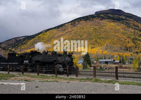 Durango und Silverton Schmalspurbahn in Silverton warten auf Abfahrt. Die Berge rund um Silverton sind mit Herbstfarben bedeckt. Stockfoto