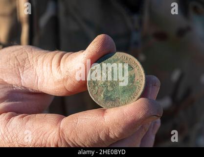 George V Penny und Victorian Münze gefunden werden, ein Metalldetektor West Lothian, Schottland. Stockfoto