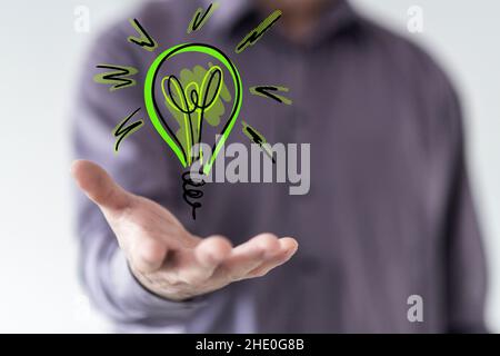 Nahaufnahme eines Mannes, der die Glühbirnenlampe zeigt, die Energie spart Stockfoto