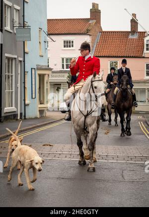 Huntsman bläst ein kleines Horn, trägt traditionelle Fuchsjagd Kleidung und reitet auf einem weißen Pferd nach Malton, vor der Jagd am zweiten Weihnachtsfeiertag. Stockfoto