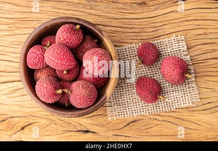 Litschi in einer Schüssel über einem Holztisch. Stockfoto