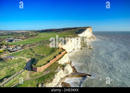 Die weißen Kreidefelsen bei Seaford Head in East Sussex England mit dem Golfplatz im Hintergrund, der an der Spitze der Klippen entlang verläuft, Aerial. Stockfoto