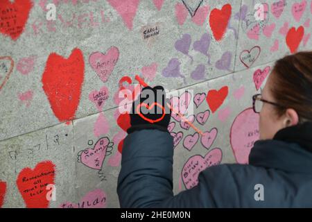 London, Großbritannien. 07th Januar 2022. Volunteer malt neue Herzen an der National Covid Memorial Wall, direkt vor dem St. Thomas' Hospital in London. Kredit: SOPA Images Limited/Alamy Live Nachrichten Stockfoto