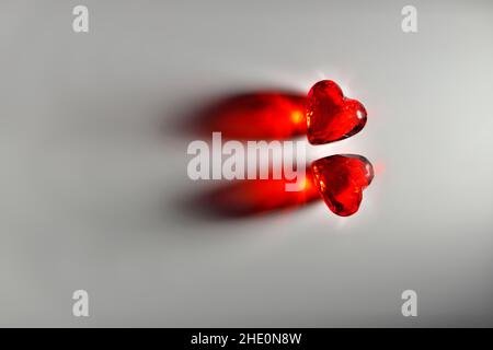 Studio Magier of Two Sparkling Red Gemstone Hearts auf grauem Studiohintergrund Stockfoto