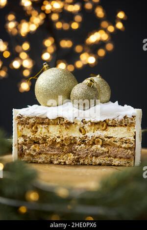 Ein Stück Kuchen auf einem Hintergrund von weihnachtslichtern. Stockfoto