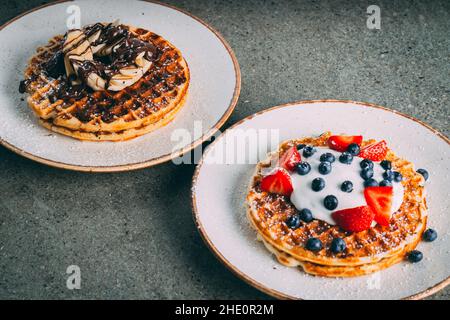 Nahaufnahme von Pfannkuchen mit Schokolade und Beeren auf einem weißen Teller serviert Stockfoto