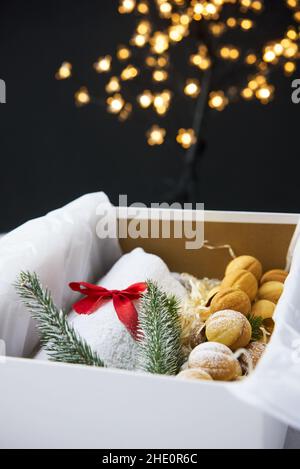 Traditioneller Weihnachtsstollen aus getrockneten Früchten und Nüssen, bestreut mit Puderzucker auf dem Hintergrund eines Weihnachtsdekor mit Kerzen Stockfoto