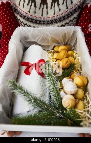 Traditioneller Weihnachtsstollen aus getrockneten Früchten und Nüssen, bestreut mit Puderzucker auf dem Hintergrund eines Weihnachtsdekor mit Kerzen Stockfoto