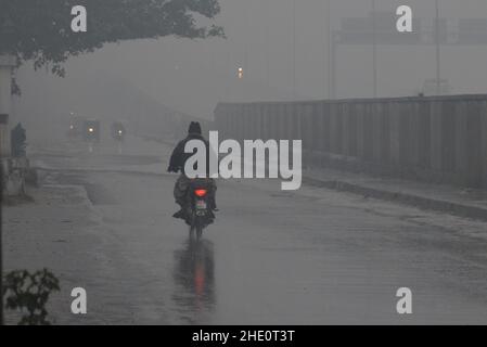 Lahore, Pakistan. 07th Januar 2022. Pakistanische Autofahrer kommen am 7. Januar 2022 während des ersten heftigen Winterregens in Lahore, Pakistan, ihren Weg. (Foto von Rana Sajid Hussain/Pacific Press/Sipa USA) Quelle: SIPA USA/Alamy Live News Stockfoto