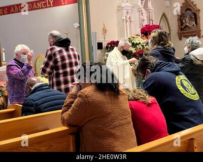 Gemeindemitglieder, die während einer Sonntagmorgendmesse in einer katholischen Kirche in Brooklyn, New York, die heilige Kommunion empfingen. Stockfoto