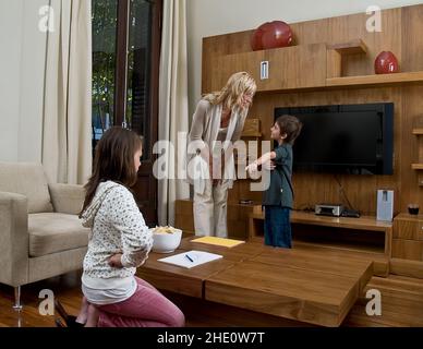 Familienmodelle, die im Wohnzimmer Hausaufgaben machen Stockfoto