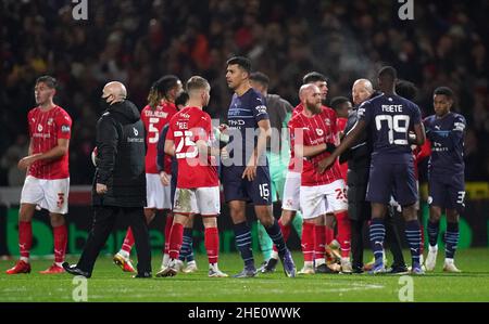 Die Spieler von Swindon Town und Manchester City geben sich nach dem dritten Spiel des Emirates FA Cup im Energy Check County Ground, Swindon, die Hände. Bilddatum: Freitag, 7. Januar 2022. Stockfoto