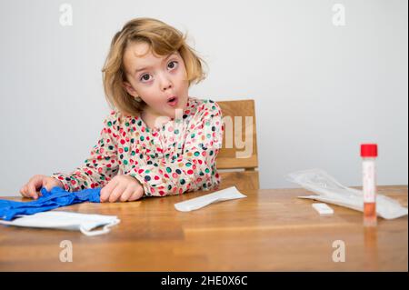 Cute blonde Mädchen Selbsttest für Corona-Virus und warten auf Ergebnisse. Stockfoto