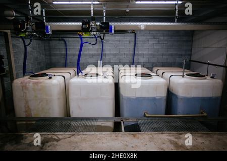 Kunststofffässer mit Kraftstoff und Schmierstoffen für Busse im Busdepot Stockfoto