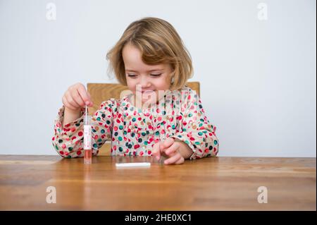 Cute blonde Mädchen Selbsttest für Corona-Virus und warten auf Ergebnisse. Stockfoto