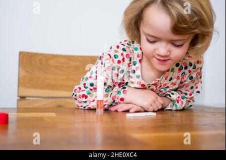 Cute blonde Mädchen Selbsttest für Corona-Virus und warten auf Ergebnisse. Stockfoto