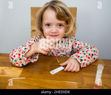 Cute blonde Mädchen Selbsttest für Corona-Virus und warten auf Ergebnisse. Stockfoto